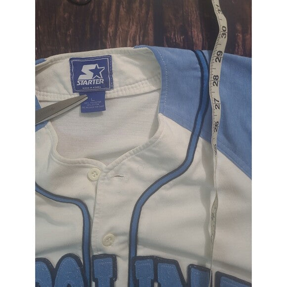 Vintage Starter Carolina Tarheels Baseball Jersey showing collar tag and tape measure on wooden background