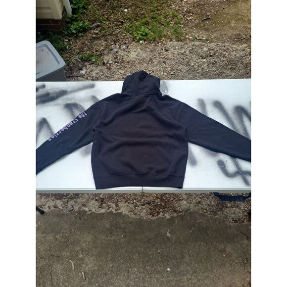Black Cranberries 1994 tour hoodie laid flat on a table showing back design with sleeve text