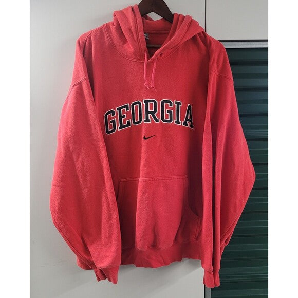 Red center swoosh Nike Bulldogs hoodie with Georgia text and front pocket hanging on wooden hanger