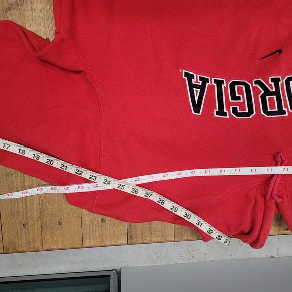 Red center swoosh Nike Bulldogs hoodie with Georgia text and measuring tape on wooden surface