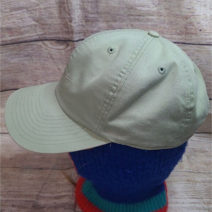 Vintage 90s Nike snapback hat in light beige displayed on a mannequin with wooden background