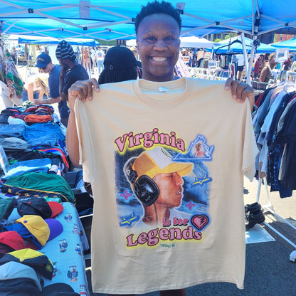 Person holding a beige Virginia Is for Legends Y2k P tee with colorful retro graphic design at outdoor market