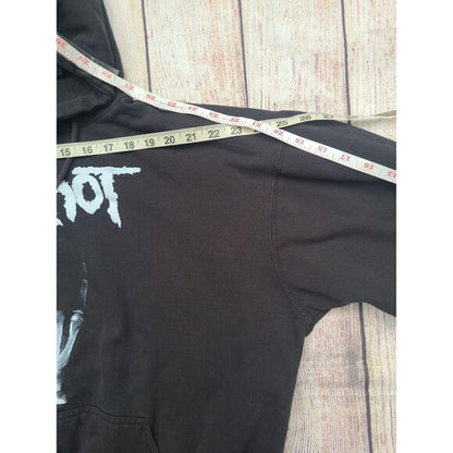 Black Y2K Slipknot Graphic Hoodie laid flat with measuring tape across shoulders showing chest width